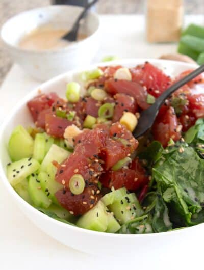 overhead view of poke bowl with garnishes in a white bowl