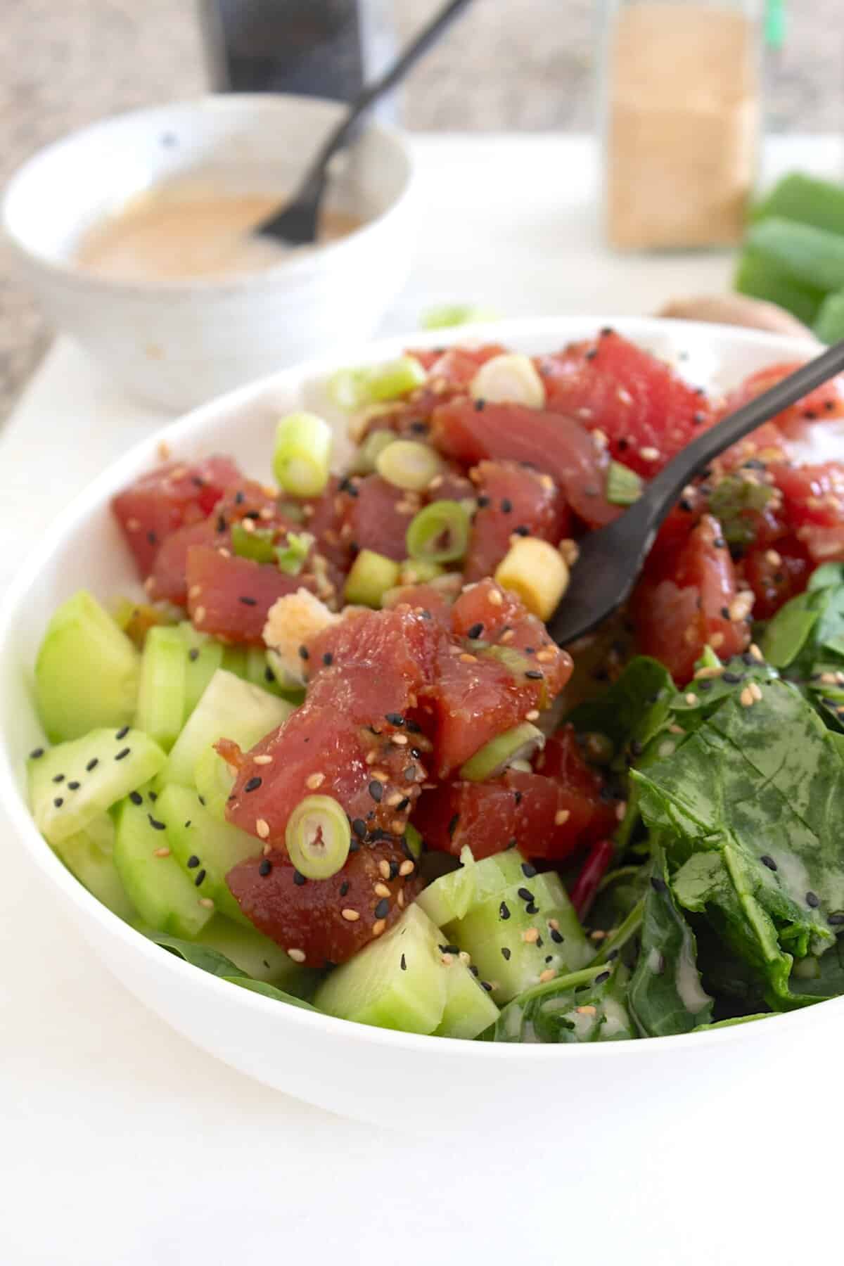 overhead view of poke bowl with garnishes in a white bowl
