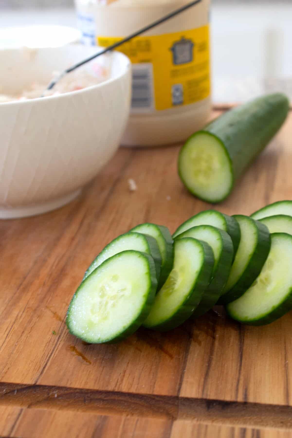 slicing cucumbers on a cutting board