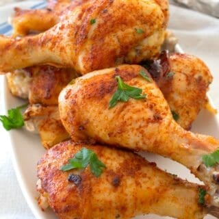 chicken drumsticks on a white platter