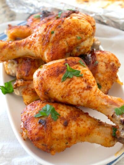 chicken drumsticks on a white platter