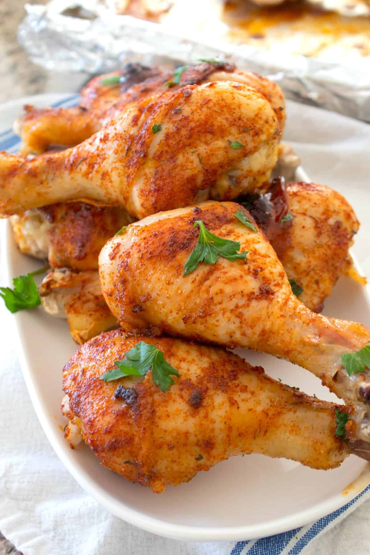 chicken drumsticks on a white platter