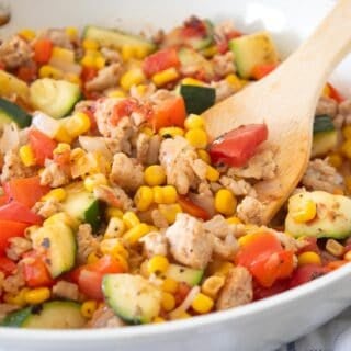 side view of chicken and zucchini skillet with spatula