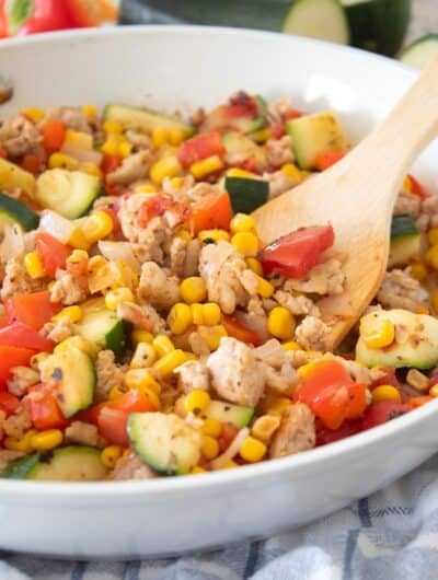 side view of chicken and zucchini skillet with spatula