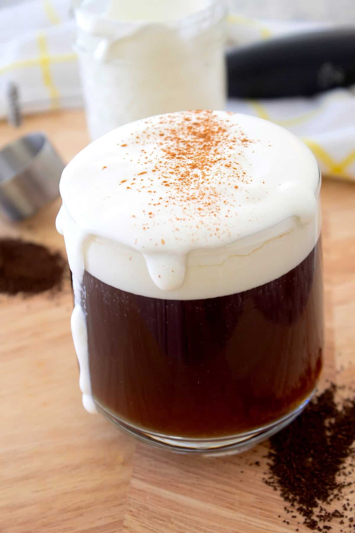 cold foam topped coffee in a clear glass 