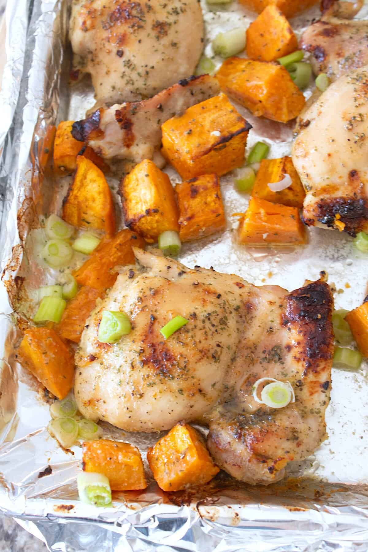 overhead view of chicken and sweet potatoes on sheet pan