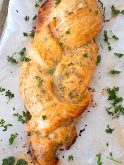 overhead view of braided salmon on sheet pan with parsley garnish