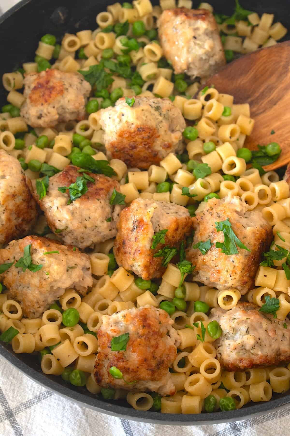 overhead view of ditalini with meatballs and a wooden spoon