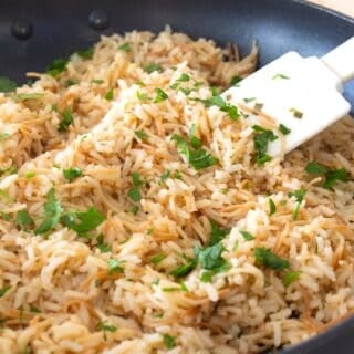 homemade rice a roni in a pan with a white spatula