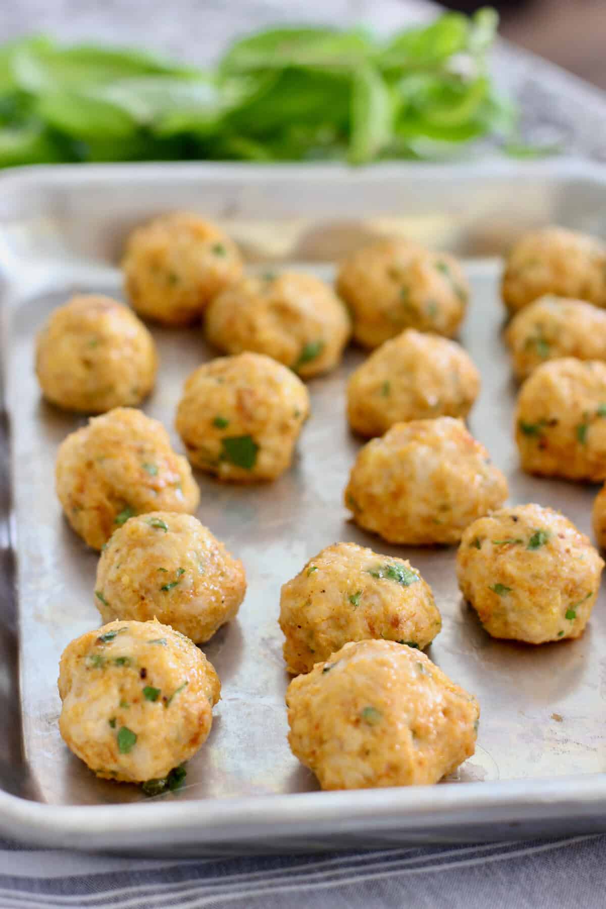 baked chicken meatballs on a sheet pan