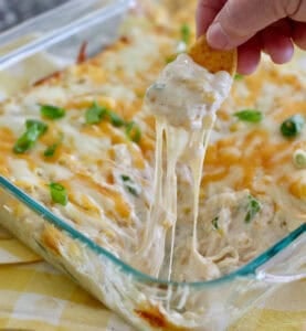 Hot corn dip out of the oven with frito scoop