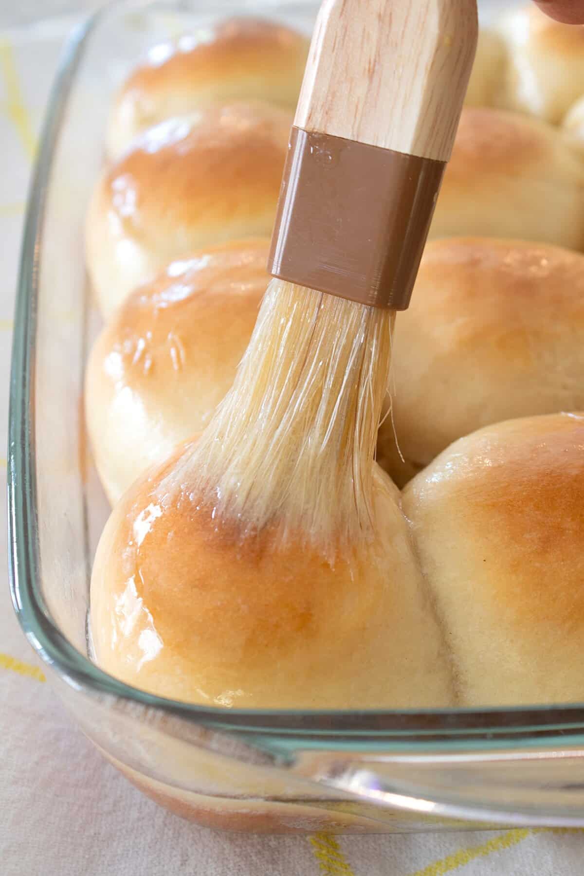 brushing rolls with butter