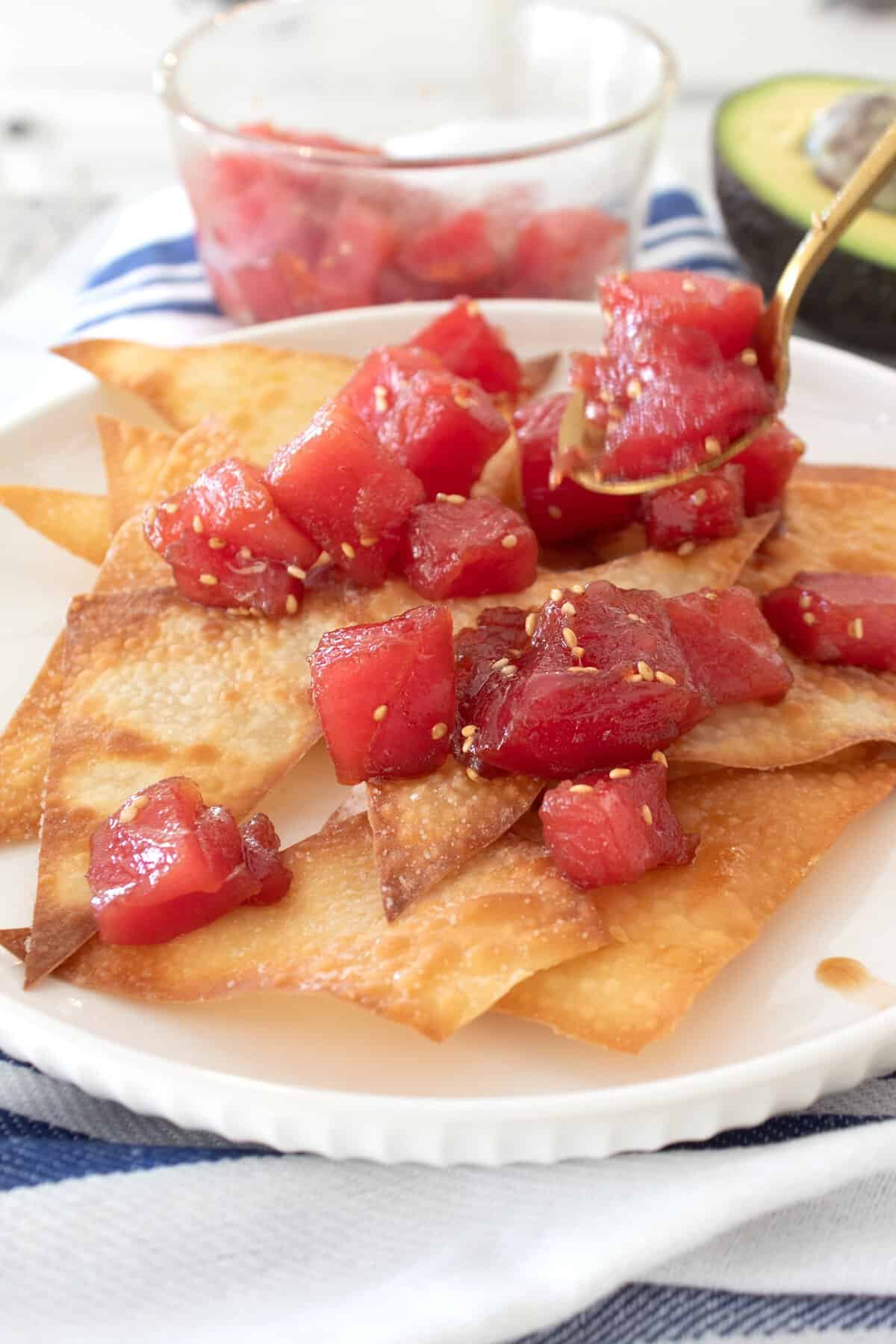 adding fresh poke to wonton nachos