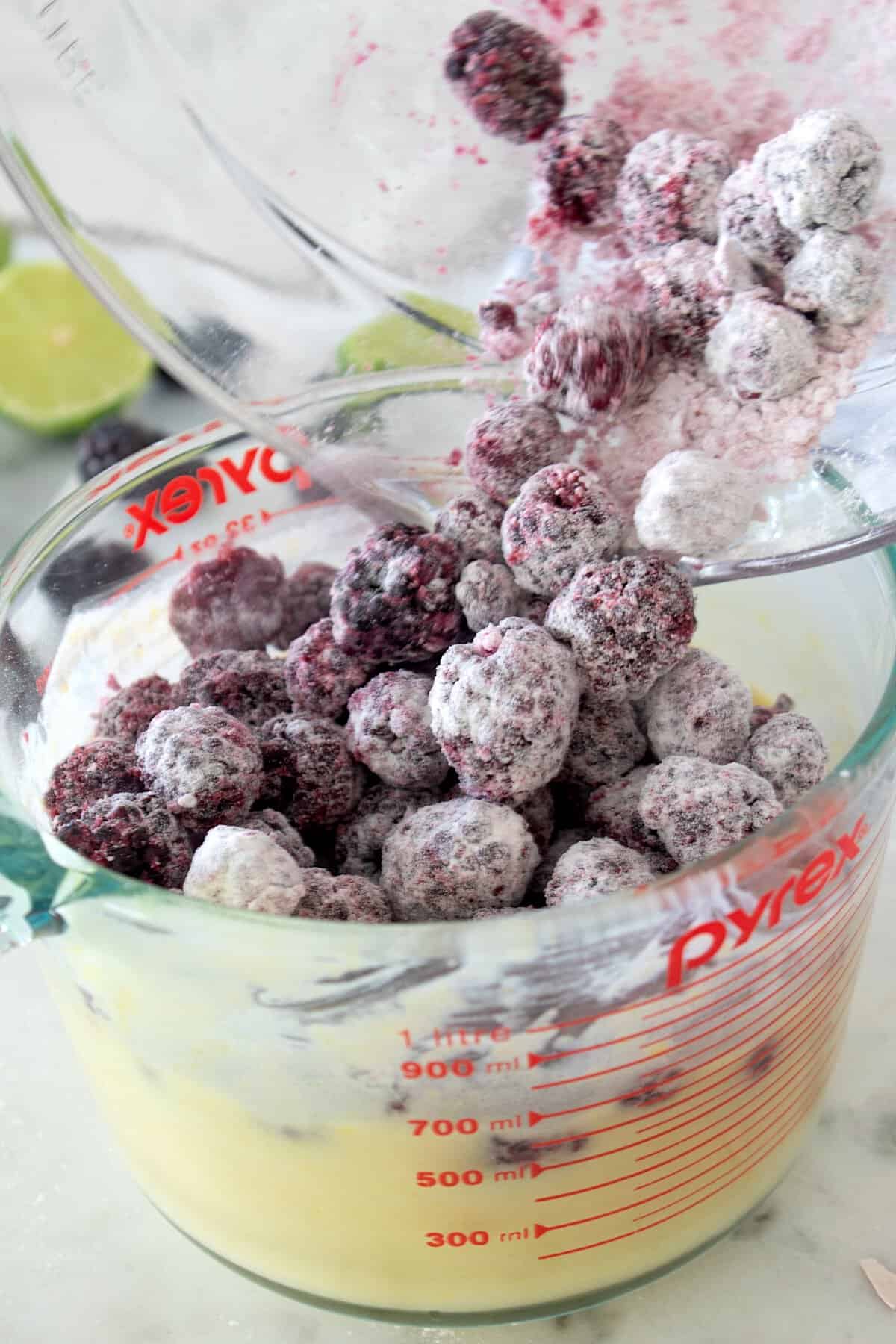 floured blackberries being added to custard filling