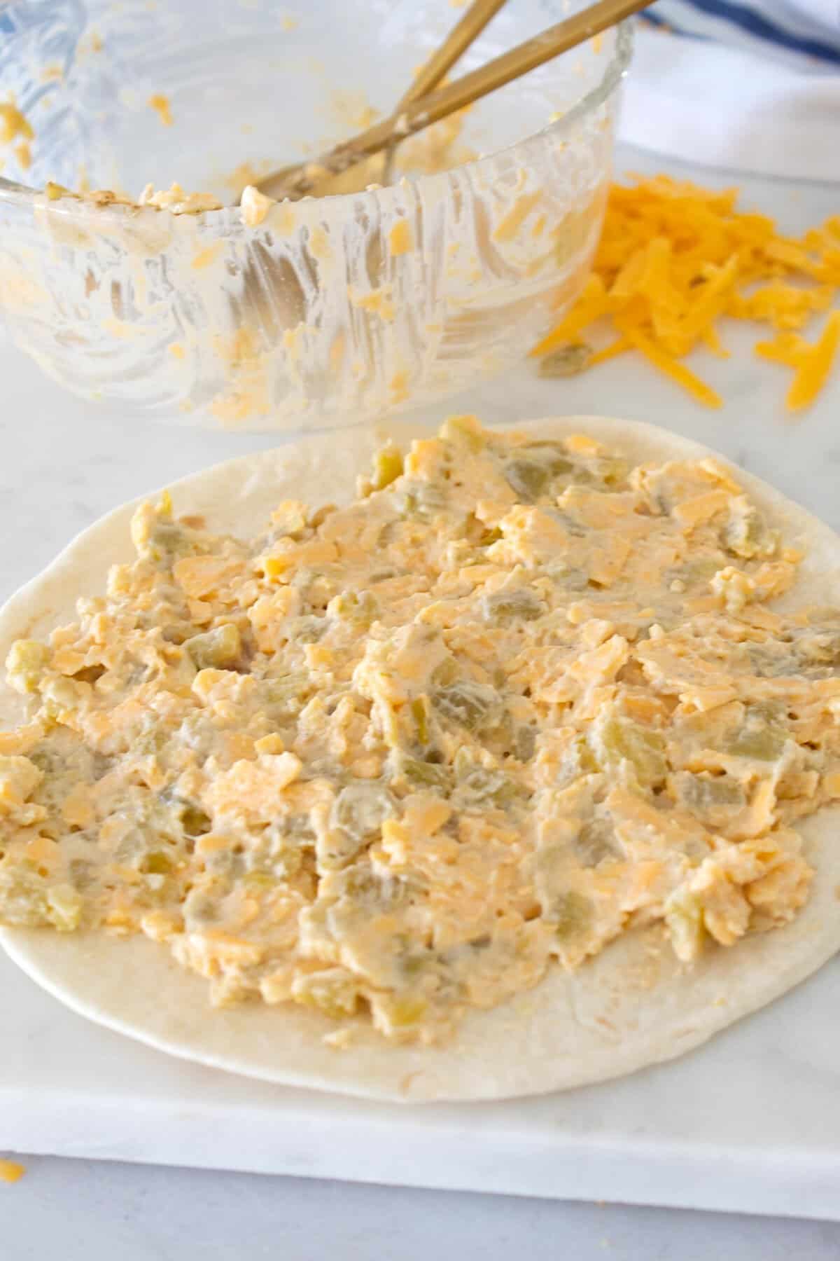 spreading cheese Chile mixture on a tortilla