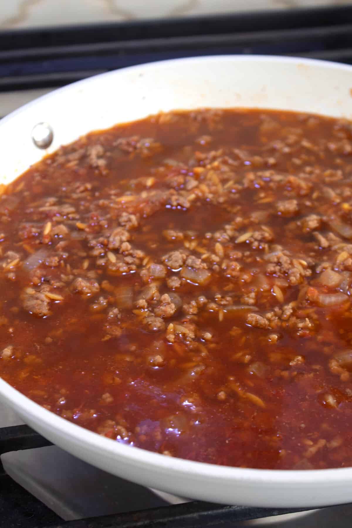adding tomato sauce to pan