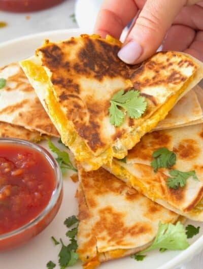 hand grabbing a slice of quesadilla