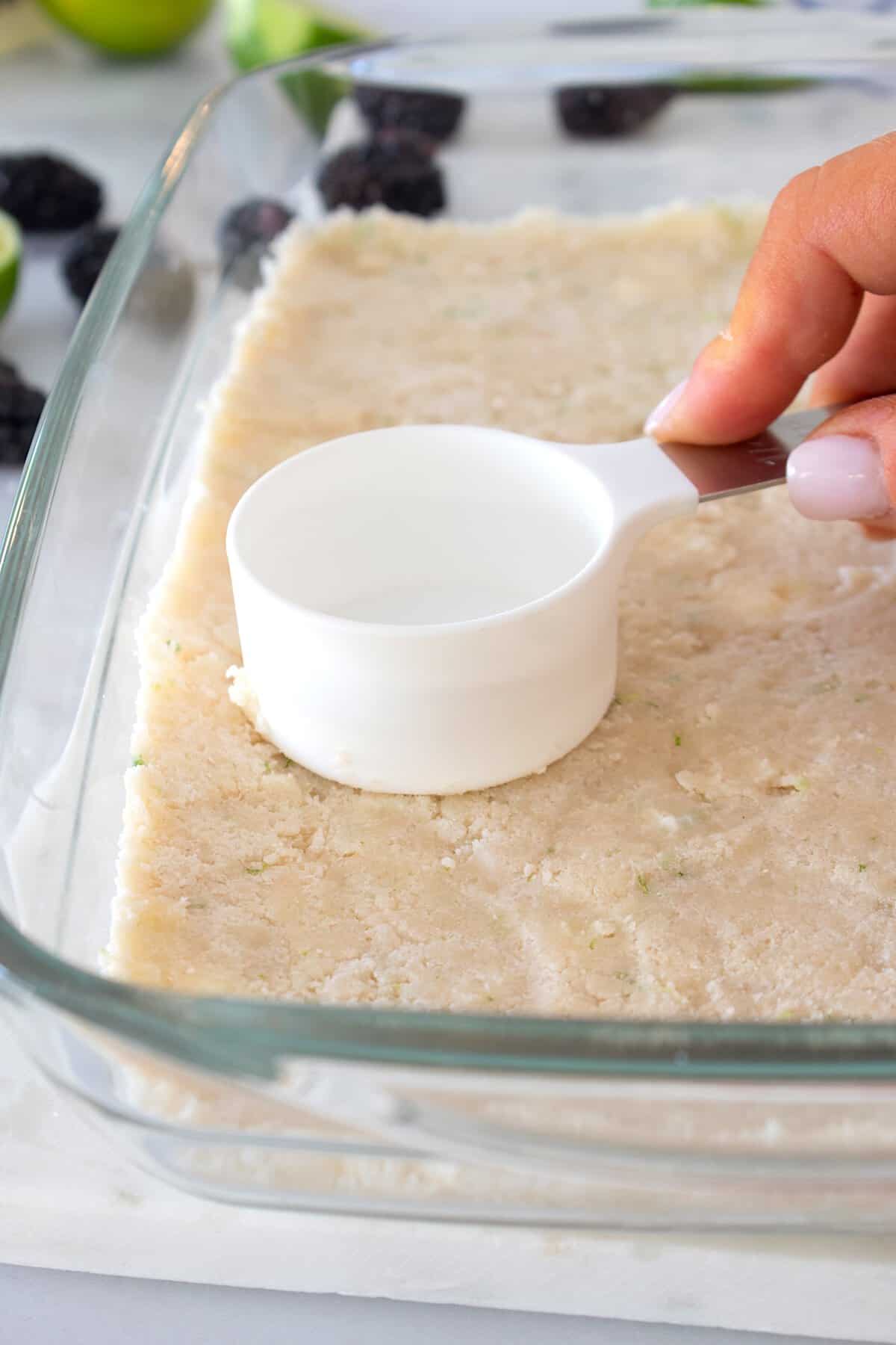 pressing down dough in pyrex dish