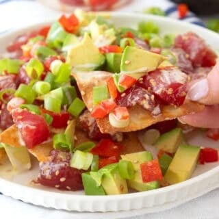 grabbing a wonton chip with poke on it