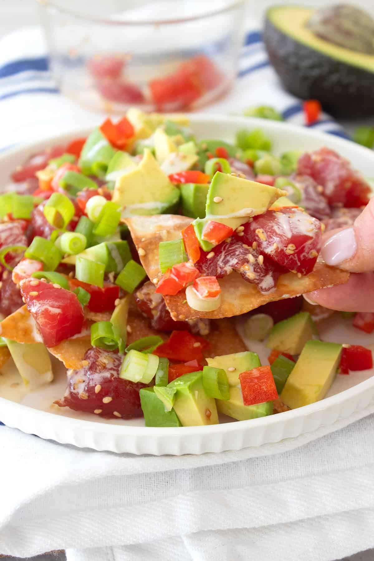 grabbing a wonton chip with poke on it