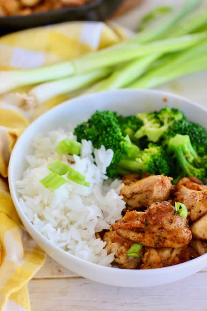 Butter chicken bites in a bowl with broccoli and rice