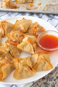 plate full of chicken wontons with sweet chili sauce