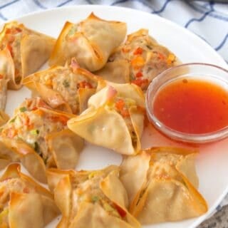 plate full of chicken wontons with sweet chili sauce