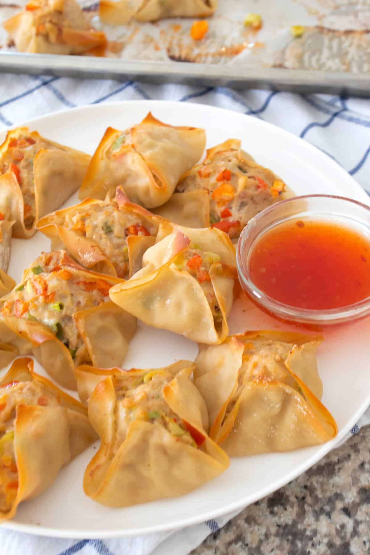 plate full of chicken wontons with sweet chili sauce