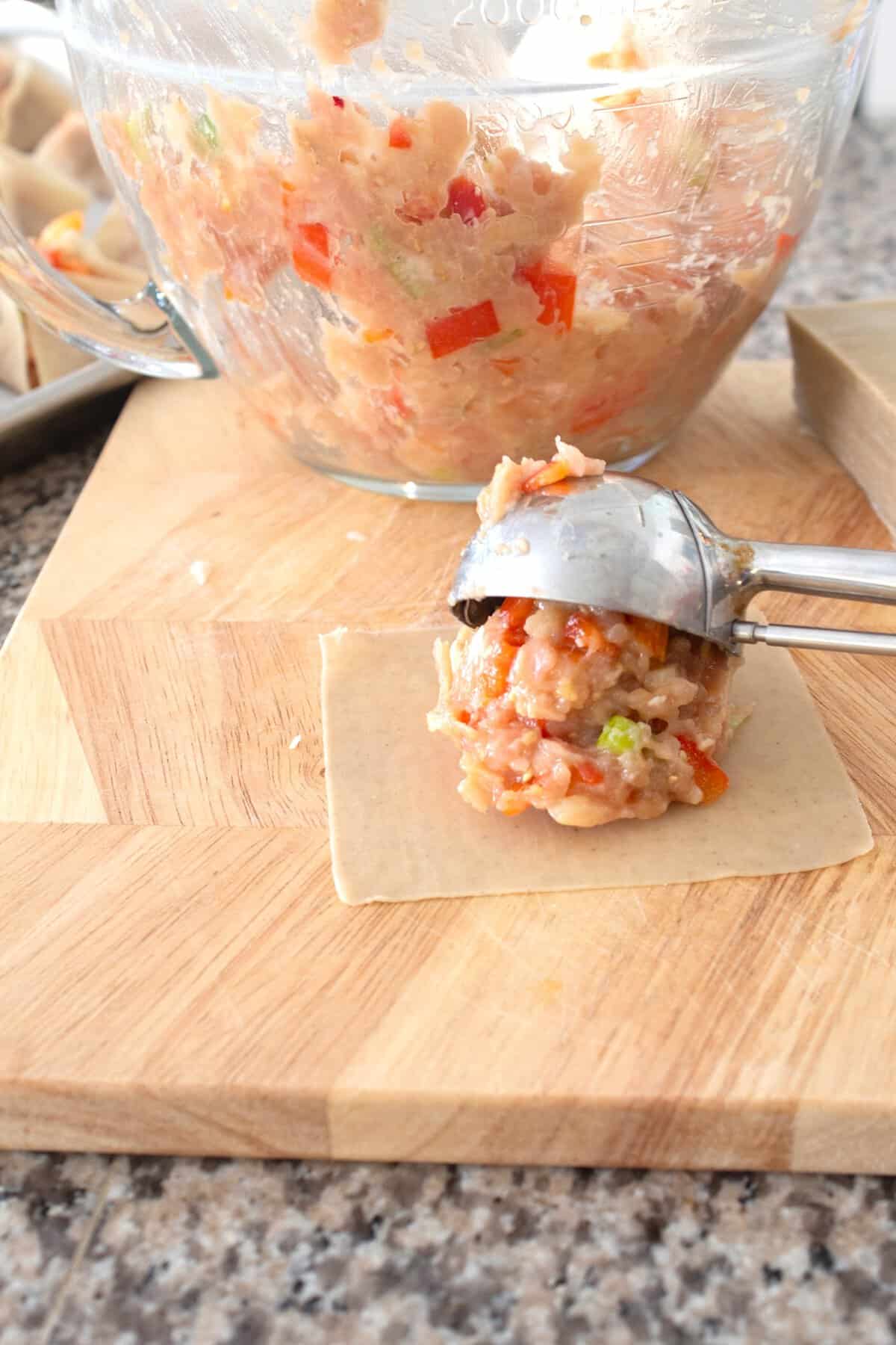 scoop ground chicken onto wonton